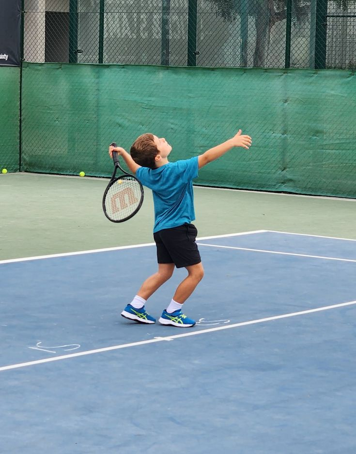 Kids running drills on a tennis court
